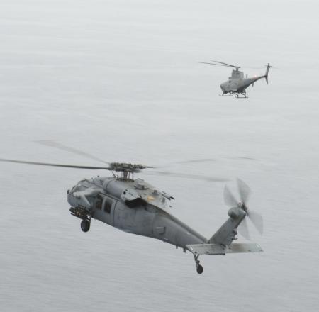 A Fire Scout UAS designates a Hellfire missile for a manned Sea Hawk helicopter. Photo: U.S. Navy